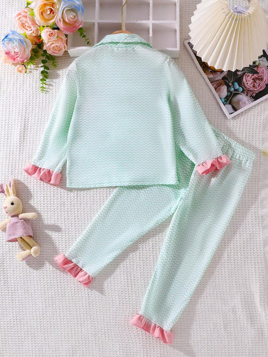 مجموعة ملابس منزلية للفتاة الصغيرة باللون الوردي وبطبعات كرتونية، تتضمن قميصاً بأكمام فلير وبنطالاً طويلاً