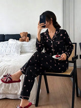 SHEIN Dreamivo طقم بيجامة قطعتين بقميص أسود بأزرار وجيوب ونقشة زهور الكرز الوردية وبنطال طويل