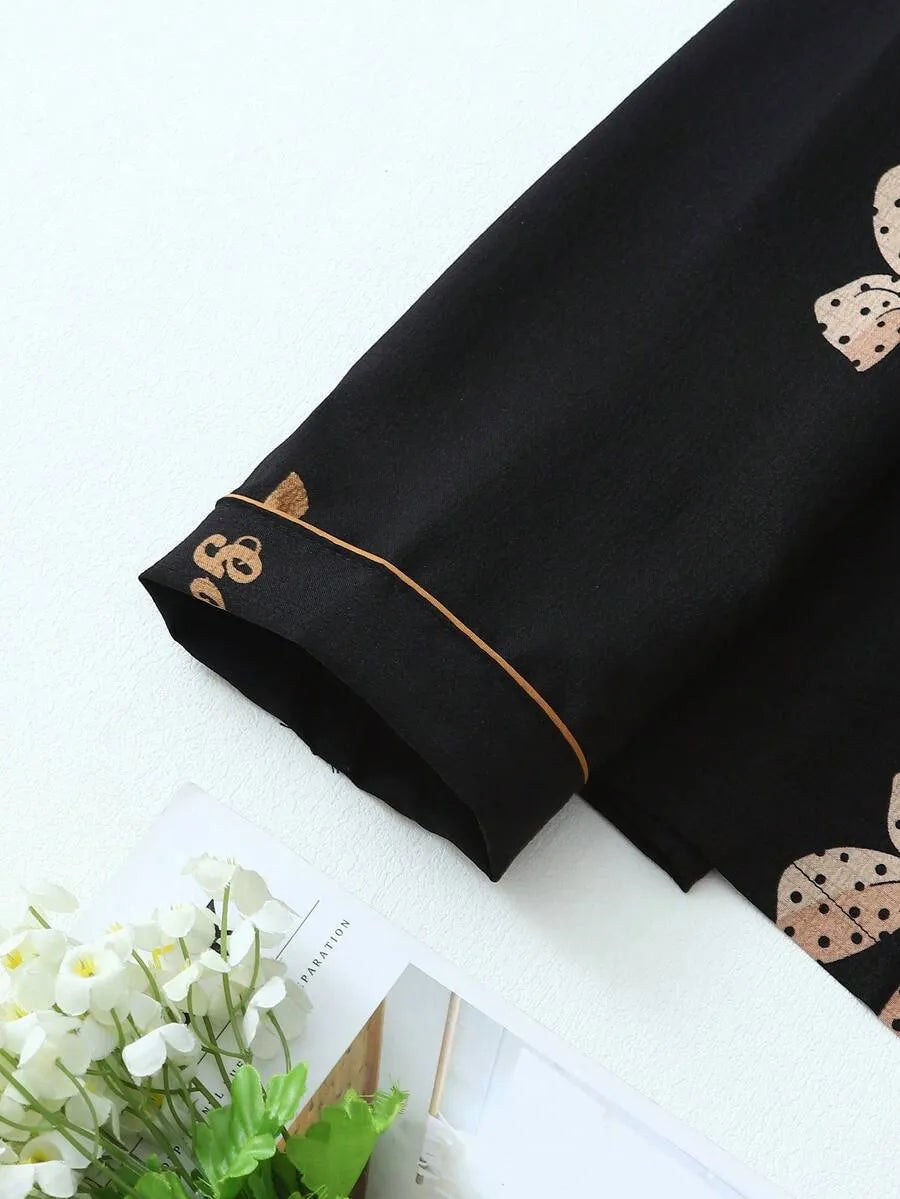 SHEIN طقم بيجامة قطعتين من الستان بقميص بأزرار أمامية وجيوب ونقشة فيونكات وبنطال طويل مجعد بلون أسود