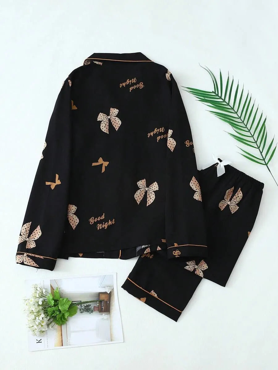 SHEIN طقم بيجامة قطعتين من الستان بقميص بأزرار أمامية وجيوب ونقشة فيونكات وبنطال طويل مجعد بلون أسود