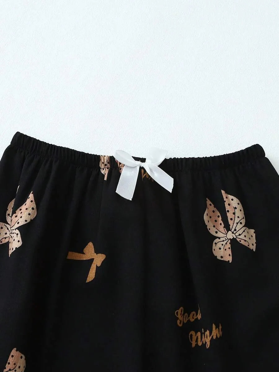 SHEIN طقم بيجامة قطعتين من الستان بقميص بأزرار أمامية وجيوب ونقشة فيونكات وبنطال طويل مجعد بلون أسود