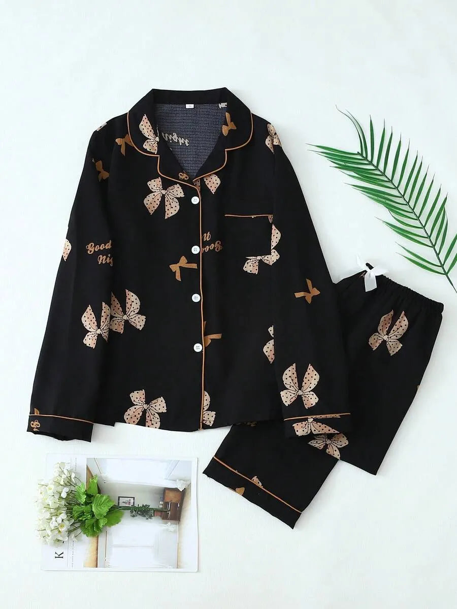 SHEIN طقم بيجامة قطعتين من الستان بقميص بأزرار أمامية وجيوب ونقشة فيونكات وبنطال طويل مجعد بلون أسود